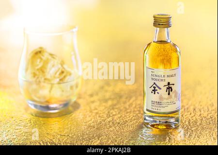 Hokkaido, japan - april 05 2023: Eine kleine Flasche Single Malt Yoichi vom japanischen Hersteller Nikka Whisky auf einer goldenen Oberfläche Stockfoto