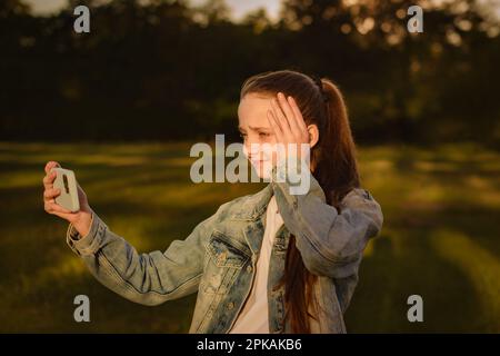 Teenager, die per Smartphone online telefonieren und sich über Probleme bei der Arbeit oder von Freunden oder Familie Gedanken machen Stockfoto