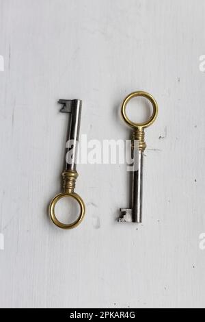 Zwei identische Schlüssel auf einem weißen Holztisch Stockfoto
