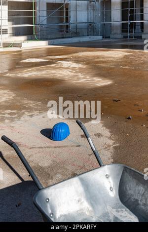 Blauer Bauarbeiterhelm liegt auf dem Boden einer verlassenen Baustelle Stockfoto