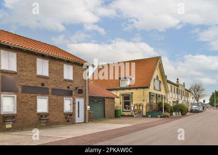 Eine leere Straße mitten in einer kleinen Stadt, mit Häusern und Autos auf beiden Seiten der Straße Stockfoto