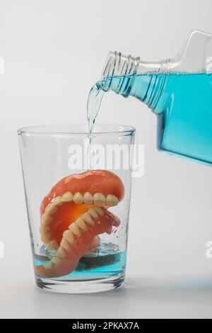 Prothese in Wasserglas, Reinigungsflüssigkeit, Symbolbild, saubere Prothesen, weißer Hintergrund, Stockfoto