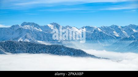 Schneebedeckte Berglandschaft über Nebel an sonnigen Wintertagen. Allgäu-Alpen bei Bad Hindelang, Bayern, Deutschland Stockfoto
