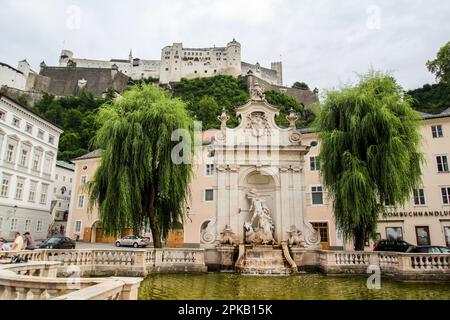 Schöner Kapitelbrunnen und die Festung Hohensalzburg in Salzburg, Österreich Stockfoto