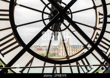 Blick auf den Louvre durch eine große Uhr vom Museum d'Orsay in Paris, Frankreich Stockfoto