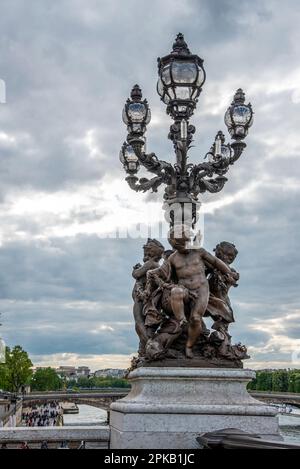 Kunstvolle klassizistische Straßenbeleuchtung mit drei Cherub auf der Brücke Alexandre III, Paris, Frankreich Stockfoto