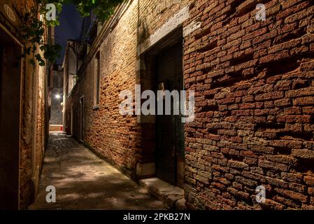 Alte Ziegelmauer in einer engen Gasse im Cannaregio District, Venedig, Italien Stockfoto