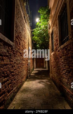 Alte Ziegelmauer in einer engen Gasse im Cannaregio District, Venedig, Italien Stockfoto