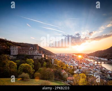 Blick über Heidelberg mit Schloss und großem Sonnenaufgang, Wolken am Himmel, Baden-Württemberg, Deutschland. Stockfoto