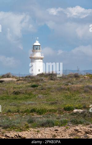 Paphos, Paphos District, Zypern - 23. März 2023 - Blick über den historischen Leuchtturm an der Küste vor blauem Himmel Stockfoto