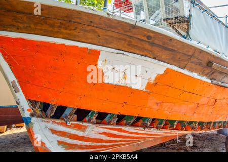 Fischerboote, die auf Wartung warten, repariert und lackiert werden müssen auf dem Reparaturhof für Boote, Neos Marmaras, Sithonia, Griechenland. Stockfoto