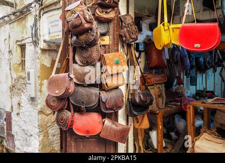 Fez, Marokko - 07. Januar 2020: Handgefertigte bunte Ledertaschen und Handtaschen hängen auf dem traditionellen Souk - Straßenmarkt in Marokko Stockfoto