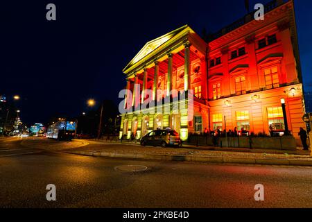 Breslau, Polen - Juni 2022: Breslau-Oper an einem dunklen Sommerabend mit farbigen Lichtern in Gelb und Rot beleuchtet Stockfoto