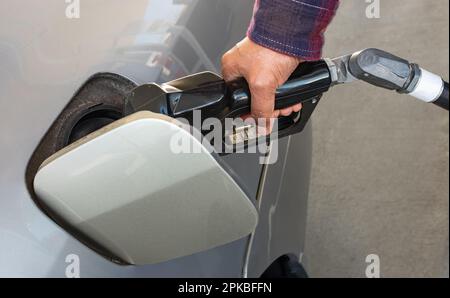 Betanken des Fahrzeugs an einer Tankstelle. Man-Fahrer betankt und pumpt Benzin an der Tankstelle ein. Autotanken läuft Stockfoto