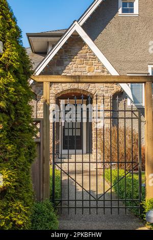 Ein luxuriöses Haus mit Toren in einem Vorort von Vancouver. Maßgeschneidertes Luxushaus mit den Toren und schön gestutztem, dekoriertem Vorgarten, Rasen in einem Garten Stockfoto