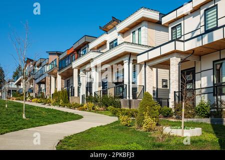 Eine perfekte Nachbarschaft. Häuser in einem Vorort am Frühling in Nordamerika. Außenfassade des Immobiliengebäudes an einem sonnigen Tag. Großer maßgeschneiderter Luxus Stockfoto