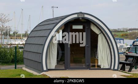 Nordirland Glamping pod neben Booten im Süßwasserhafen. Coney Island Glamping Pod Teil der Island Pods Gruppe, die man in Kinnego Lough Neagh mieten kann. Stockfoto