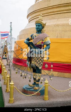 Thailändische Skulptur vor dem Hintergrund einer großen goldenen Stupa des Wat Saket Tempels in Bangkok Thailand. Stockfoto
