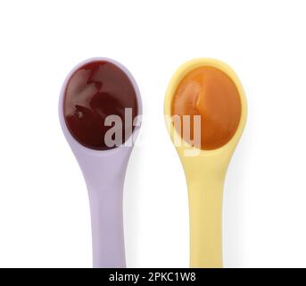 Gesunde Babynahrung in Löffeln auf weißem Hintergrund, Draufsicht Stockfoto