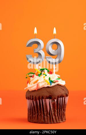 Kerze Nummer 39 - Kuchen zum Geburtstag auf orangefarbenem Hintergrund Stockfoto