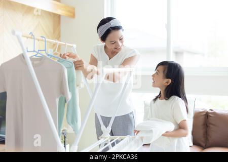 Mutter und Tochter Wäsche Falten Stockfoto