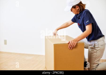 Arbeiterin, die den Deckel einer Pappschachtel schließt Stockfoto