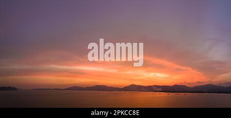Atemberaubender Himmel bei Sonnenuntergang über dem Meer aus der Vogelperspektive. Farbenfrohe Wolke am hellen Himmel des Sonnenuntergangs über dem Ozean am Khao Khad Phuket. Majestätischer Sonnenuntergang oder Sonnenaufgang Stockfoto