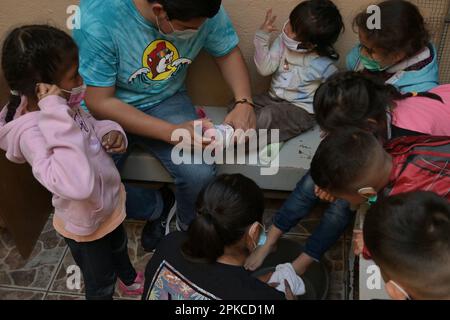 Tijuana, Mexiko. 06. April 2023. Die Menschen nehmen an einer Zeremonie der Heiligen Woche Teil, bei der Freiwillige aus der Casa del Migrante die Füße von Migranten waschen und die Erinnerung der zwölf Apostel an Jesus widerspiegeln, denn ich habe Ihnen ein Beispiel gegeben, dass Sie tun können, was ich Ihnen getan habe. Pater Pat Murphy vergleicht Jesus' Handlung mit der Not von Migranten und der ungerechten Behandlung von Migranten im Zusammenhang mit dem CDC-Programm Titel 42 und den jüngsten Ereignissen der 41 toten Migranten in Ciudad Juarez. Kredit: Carlos Moreno/dpa/Alamy Live News Stockfoto