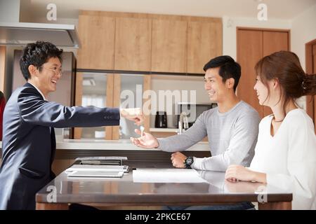 Ein Paar, das die Schlüssel vom Immobilienmakler bekommt Stockfoto