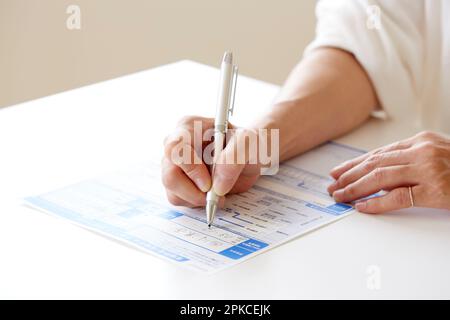 Frauenhand, die Papierkram ausfüllt Stockfoto