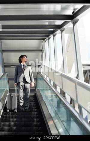 Büroangestellter auf einer Rolltreppe Stockfoto