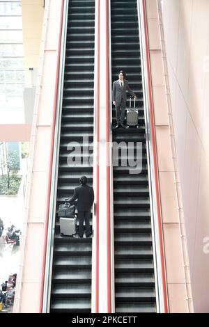 Büroangestellter auf der Rolltreppe Stockfoto