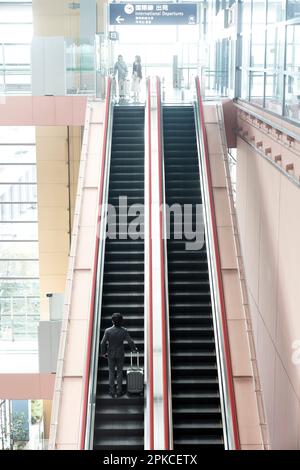 Büroangestellter auf der Rolltreppe Stockfoto