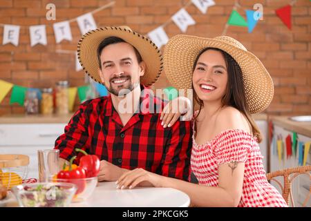 Ein junges Paar feiert Festa Junina (Juni-Festival) in der Küche Stockfoto