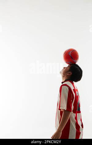 Fußballspieler balanciert den Ball auf der Stirn Stockfoto