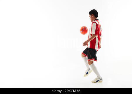 Ein Fußballspieler, der einen Ball hebt Stockfoto