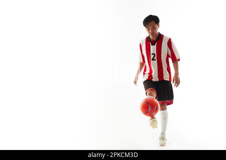 Ein Fußballspieler, der einen Ball hebt Stockfoto