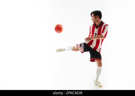 Ein Fußballspieler, der einen Ball hebt Stockfoto