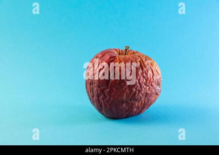 Fauler Apfel auf einer farbigen Nahaufnahme Stockfoto