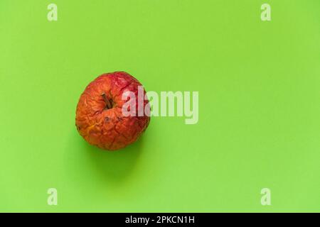 Fauler Apfel auf einer farbigen Nahaufnahme Stockfoto