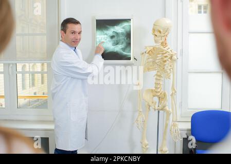 Männlicher Arzt im Vortrag - Skelett Stockfoto