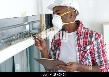 Ein Zimmermann mit Maske arbeitet in seiner Werkstatt Stockfoto