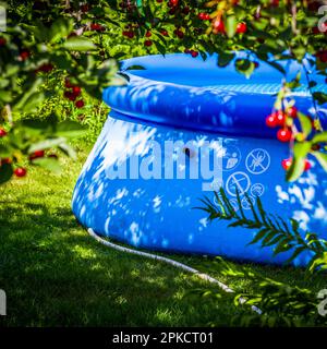 Aufblasbarer blauer Pool im Hinterhof eines privaten Hauses. Stockfoto