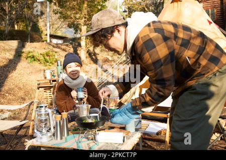Männer und Frauen essen auf einem Wintercampingplatz Stockfoto
