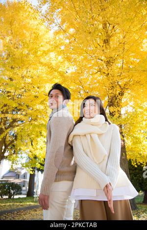 Ein Paar in den 20s pflückt Gingko-Nüsse Stockfoto
