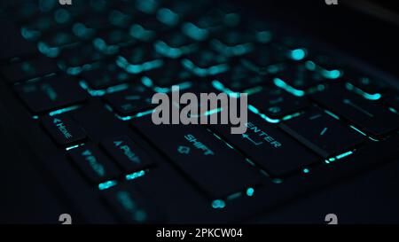 Eine Computertastatur ist ein Eingabegerät, mit dem eine Person Buchstaben, Zahlen und andere Symbole eingeben kann Tastatur mit grüner Hintergrundbeleuchtung Stockfoto