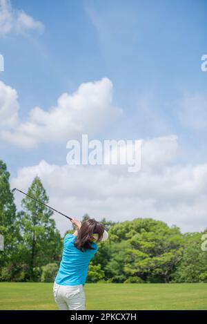 Eine Frau mittleren Alters, die Golf spielt Stockfoto