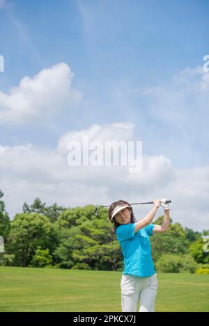 Eine Frau mittleren Alters, die Golf spielt Stockfoto