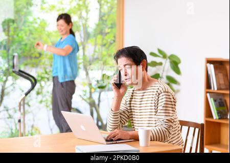 Telearbeit, Mann und Frau mittleren Alters, die Laufmaschine spielen Stockfoto