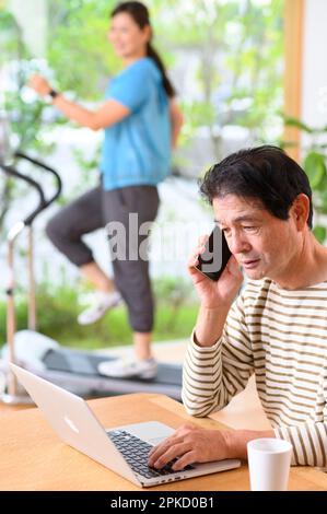 Telearbeit, Mann und Frau mittleren Alters, die Laufmaschine spielen Stockfoto